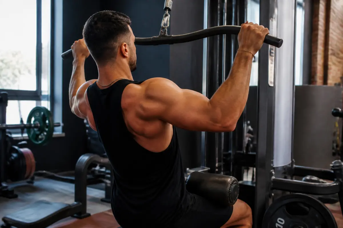 Homme effectuant un tirage à la poulie horizontal pour exercice de musculation du dos