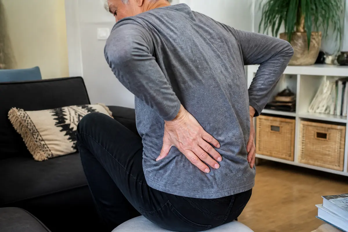 Personne souffrant de douleurs lombaires assise, contexte mal de dos lié au cancer